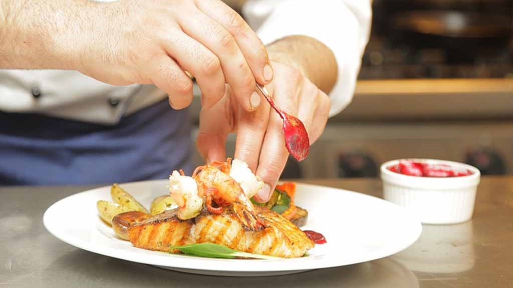 Seafood dish prepared by a man's hands.