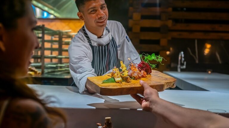 A chef in Garza lanca Los Cabos offers a luxury dish.