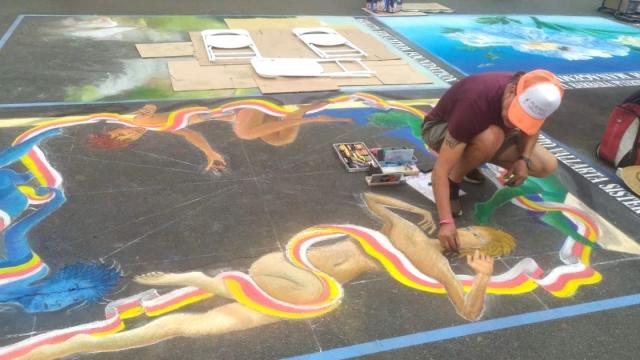 Artist drawing on the floor at I Madonnari festival