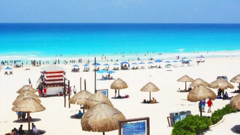 Delfines Beach Cancun with palapas and umbrellas on the sand