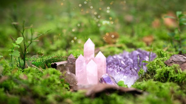 Natural crystal gemstones in magic forest, minerals on green moss, self-discovery and mental healing concept