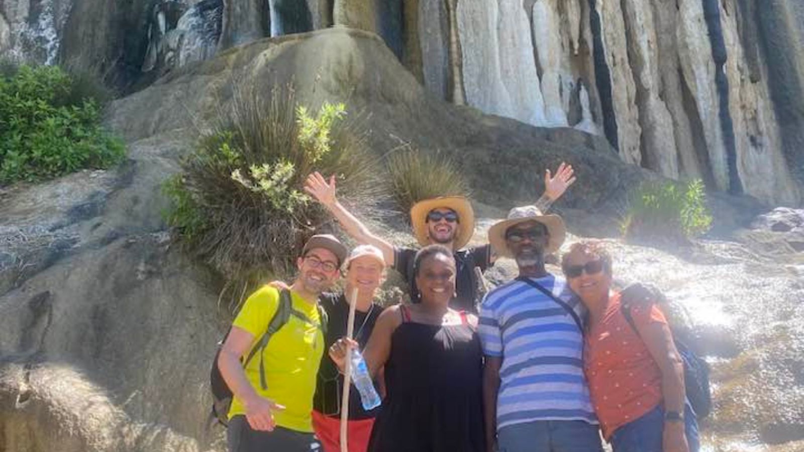 People posing in front of a mountain