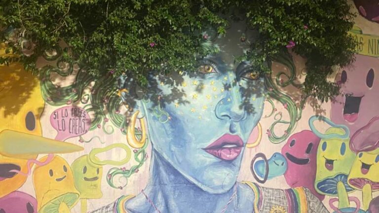Paintinf of a womwn on a wall with a tree crown as hair