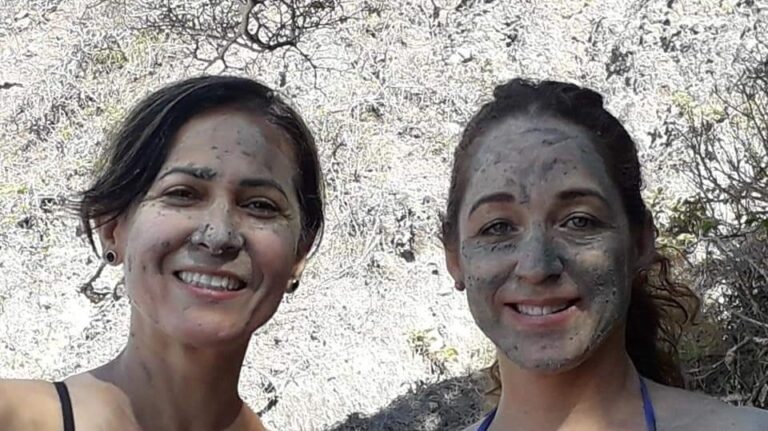 two women with their face covered by mud