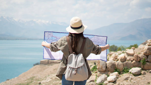 Tourist woman turns her back to the camera and looks at the map