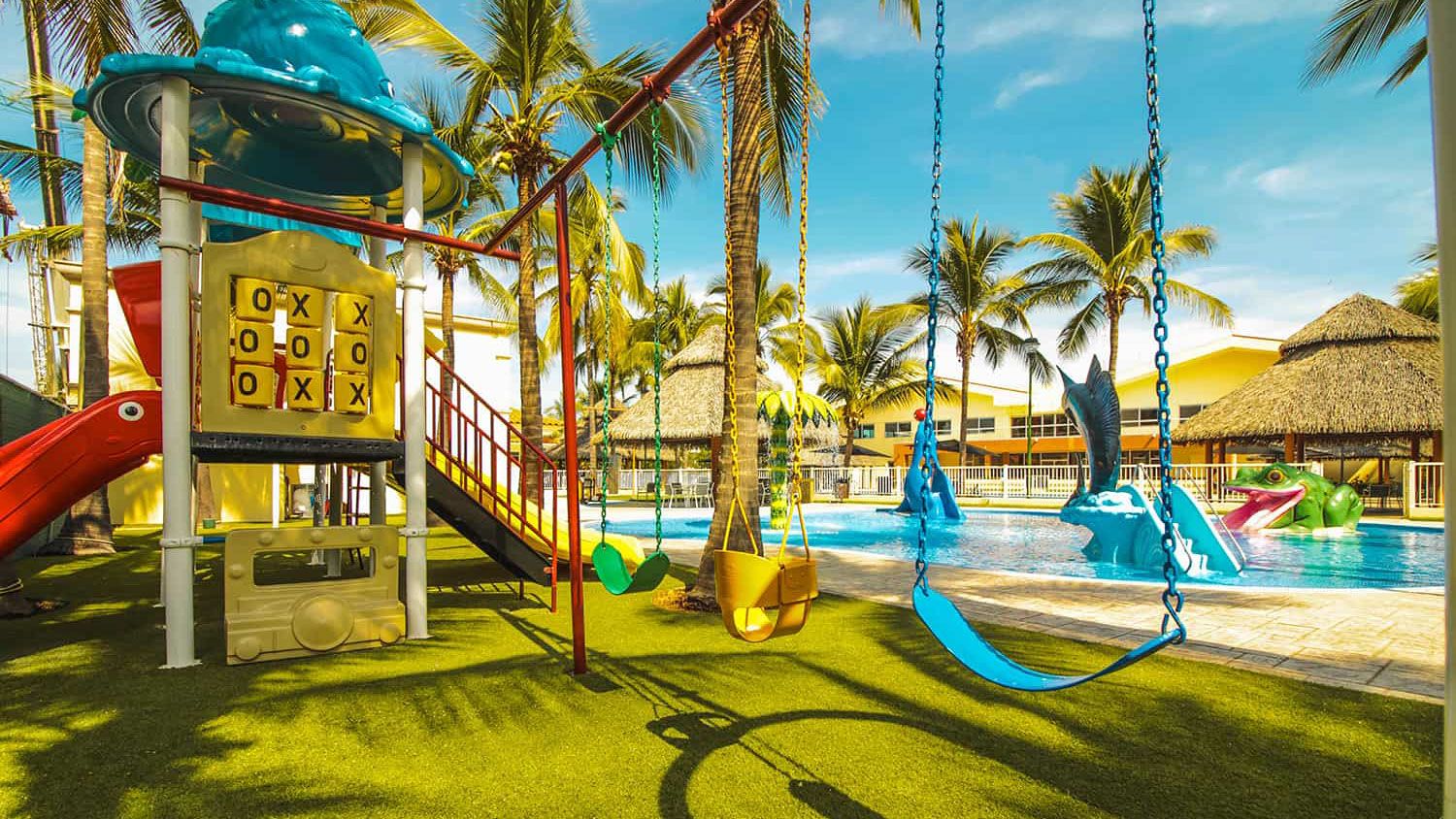 An enchanting glimpse of Los Tigres Kids Park, a haven for families. The image showcases a vibrant kids' pool, a bustling play center, and a picturesque landscape of lush green grass. It's the perfect setting for parents to create lasting memories with their children