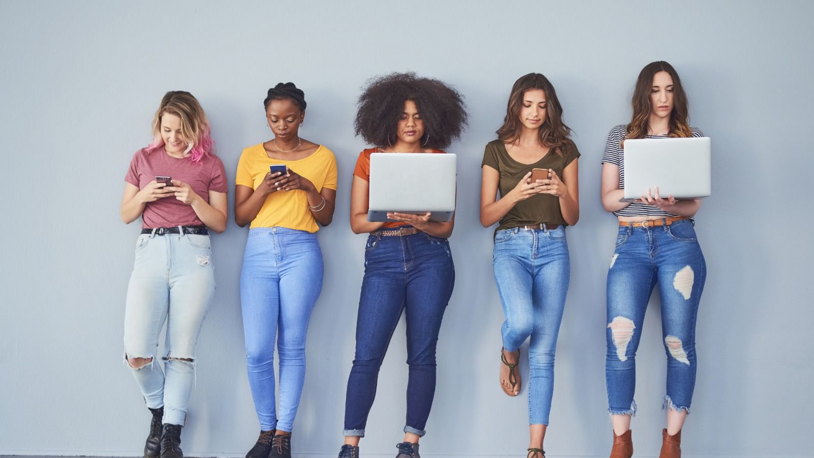 Women lined up with electronic devices in their hands