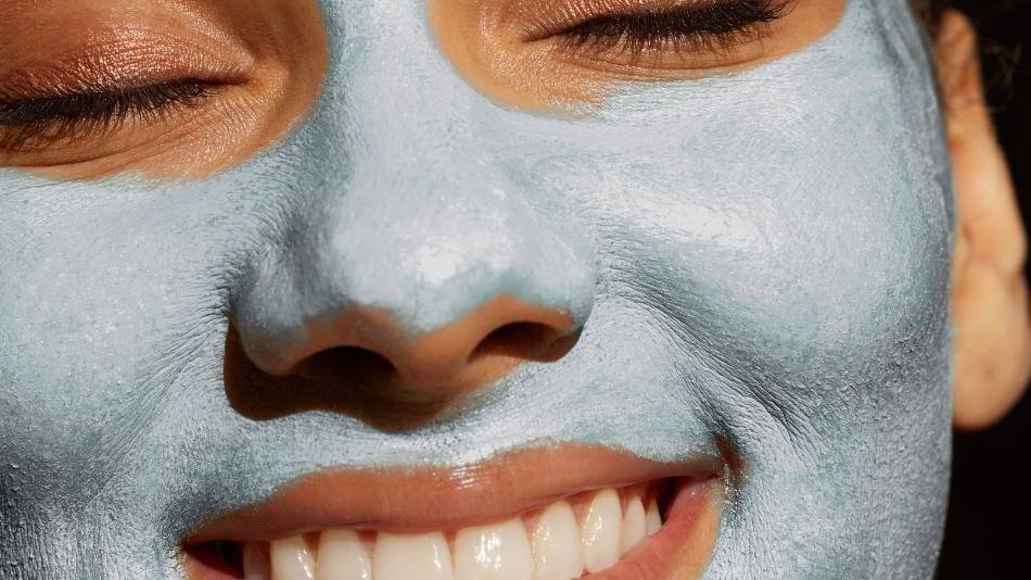 Woman smiling with TRU ALCHEMY's Mystic Mask on her face