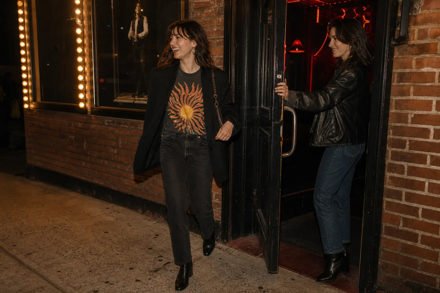 Open black blazer over a graphic tee with dark jeans and black ankle boots