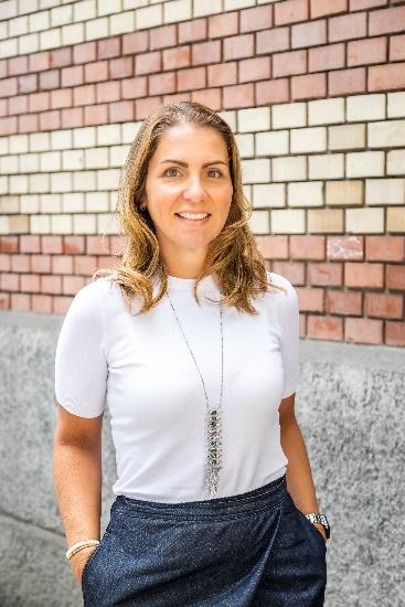 Juliana Gallo standing in front of brick wall 