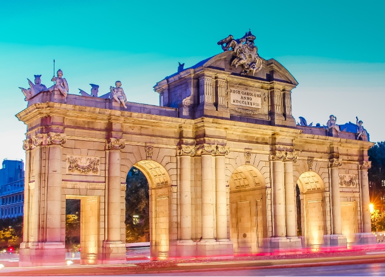 Sundown at Puerta de Alcala with streaming car lights in Madrid, Spain