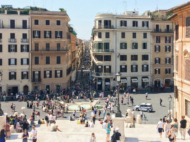 Busy historic plaza with people and cars