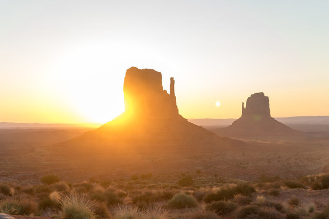 Sun setting behind mesa in Monument Valley, US 