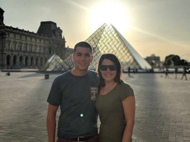 A couple standing in front of the Inverted Pyramid Lourvre