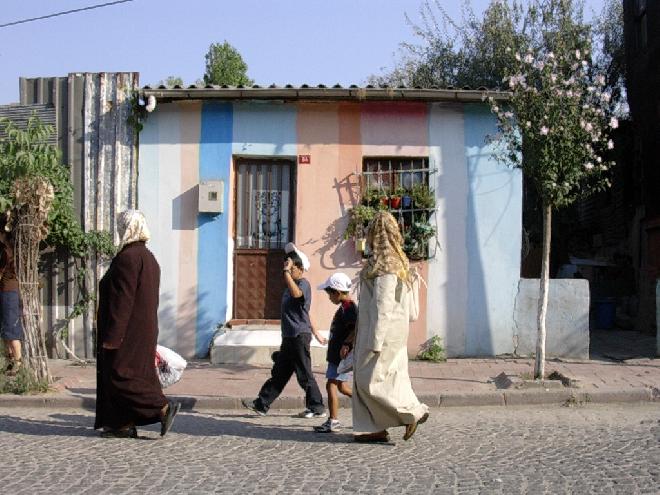 Women passing by a house in Fener