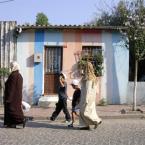 Women passing by a house in Fener