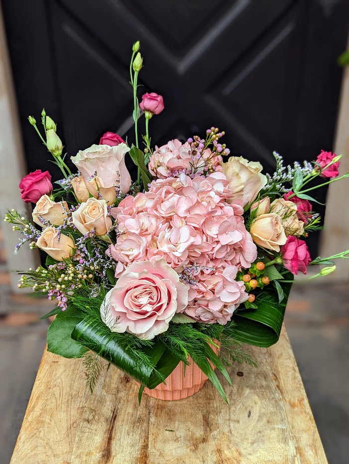 The Watering Can | An all pink bouquet centered around a hydrangea and presented in a coral ceramic vase.