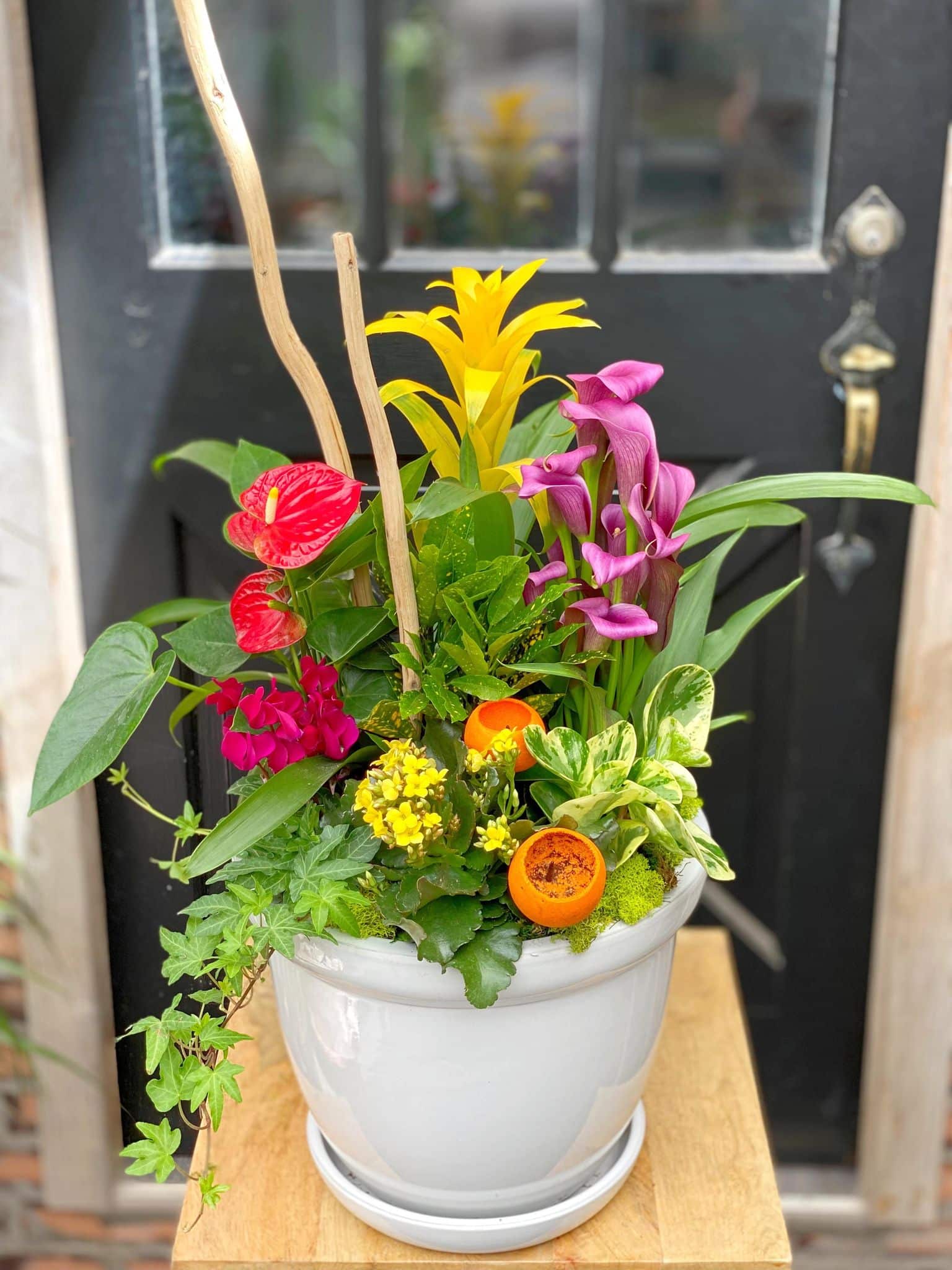 A large planter with a mix of bright, warm coloured tropical plants.