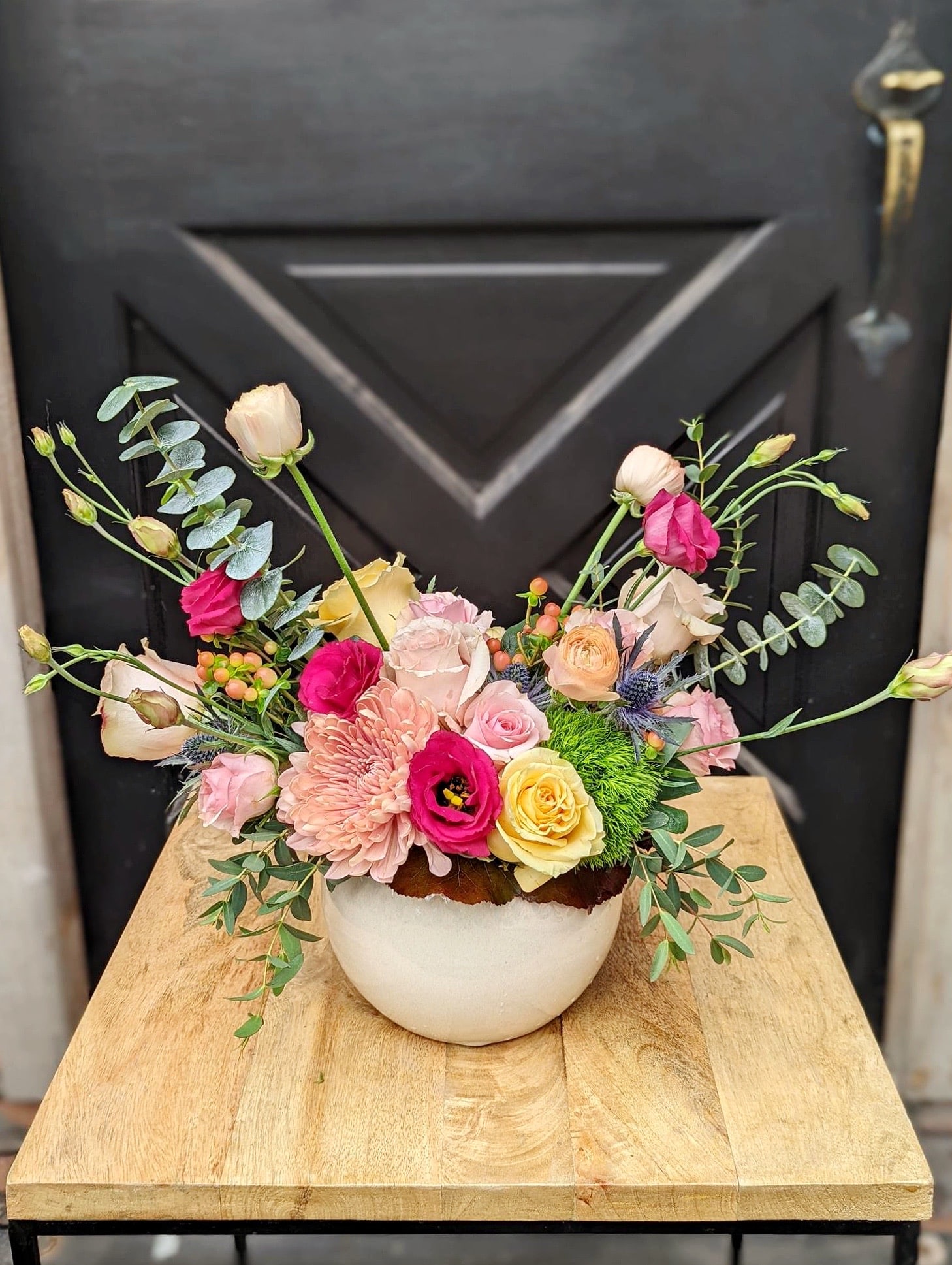 A european arrangement of expanded blush tones featuring roses.