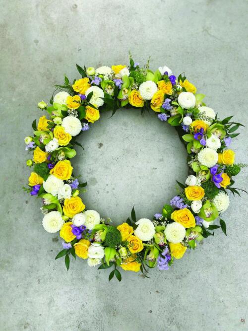 A large yellow, white, and purple floral wreath.