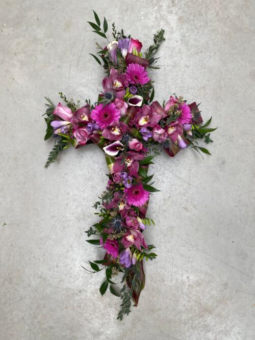 A hot pink and purple floral cross.