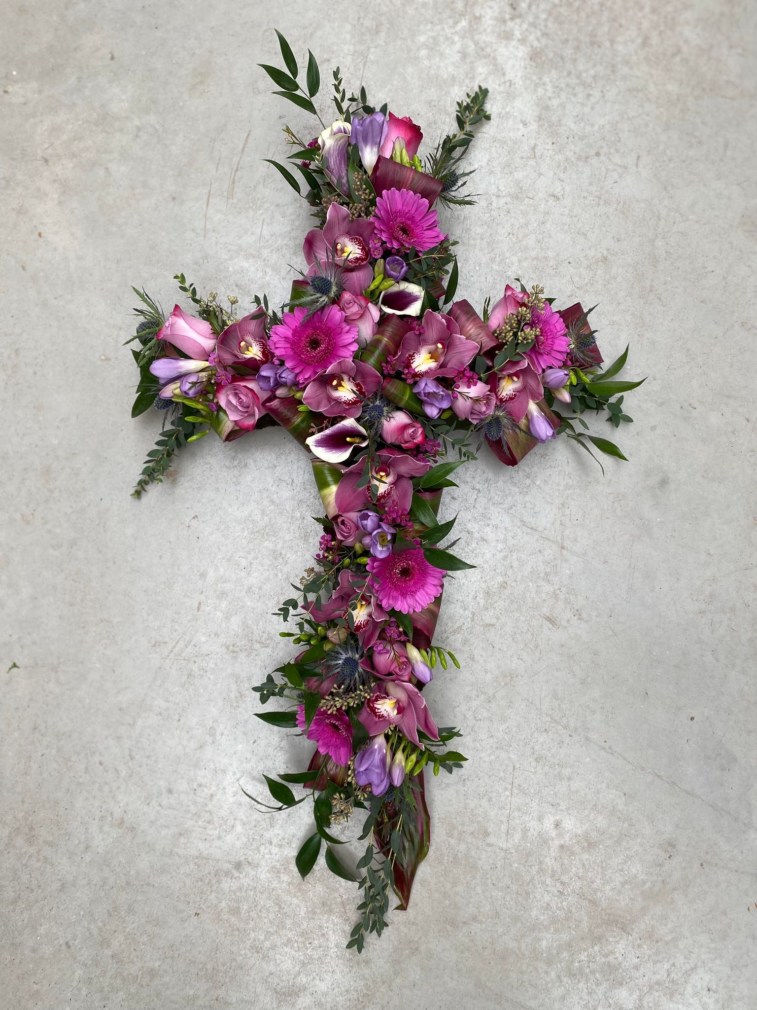 A hot pink and purple floral cross.