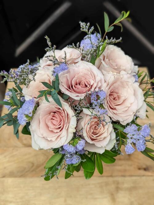 A small bouquet of blush roses with blue statice, limonium and minimal greenery.