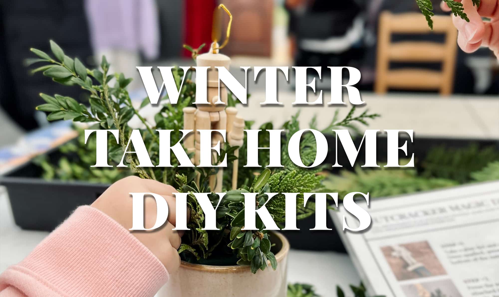 Promotional graphic reading 'Winter Take Home DIY Kits' over a photo of hands assembling a festive evergreen kit with a wooden nutcracker.