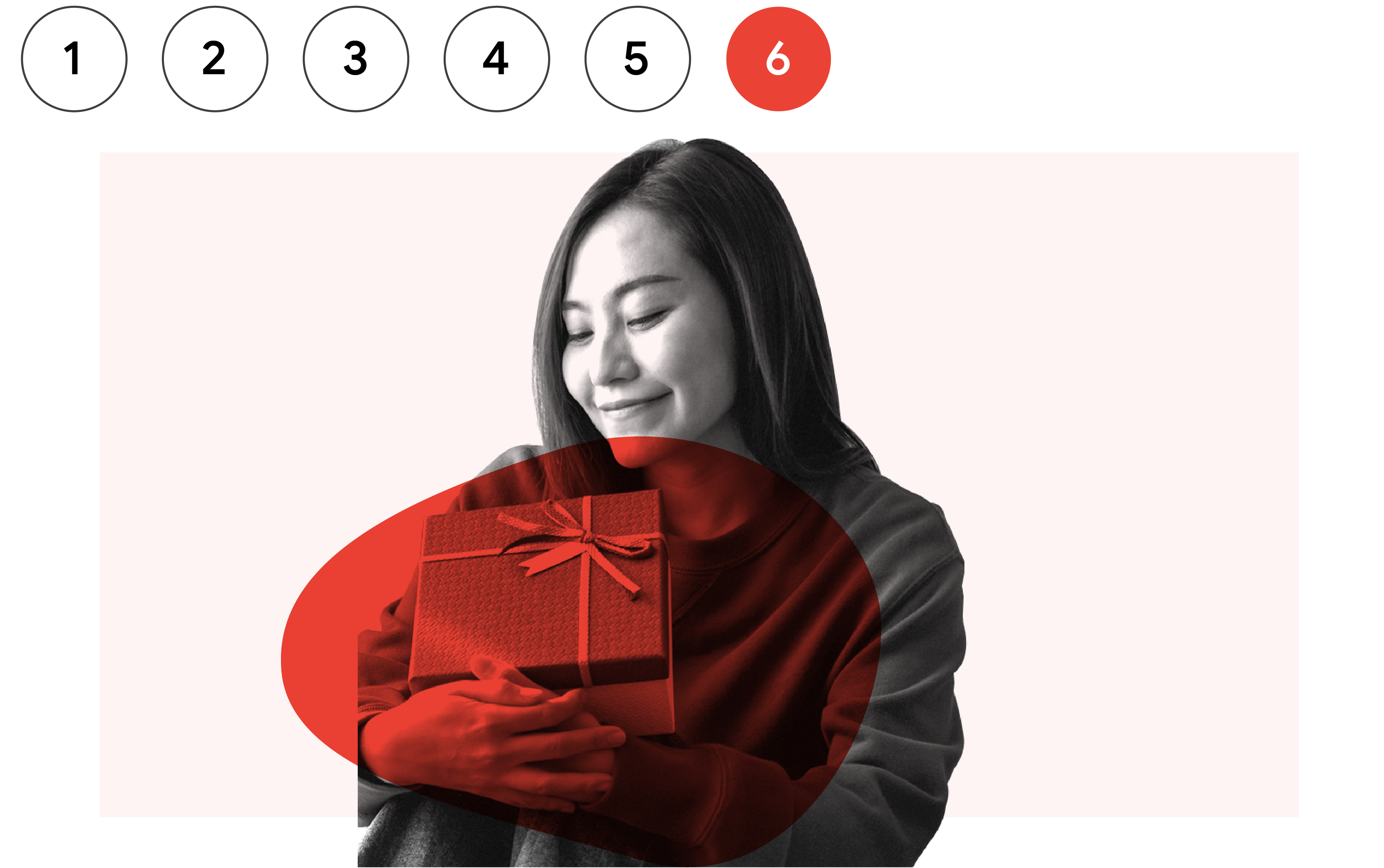 A smiling woman wearing a sweater carries a holiday gift.