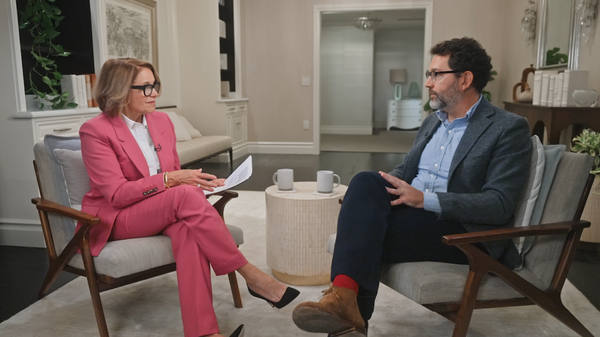 Future Ready: Cyber Risk with Katie Couric and Google’s Royal Hansen. Couric has light brown hair, light skin, and wears a coral pantsuit. Hansen has dark hair, a gray beard, light skin, and wears glasses, a gray sport coat, and black pants.