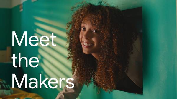 Meet the Makers: Grammarly & Ghost Note. A young woman with light brown skin and long curly brown hair smiles wryly as she climbs into a dorm room through the heating vent, just her head and one arm poking out.