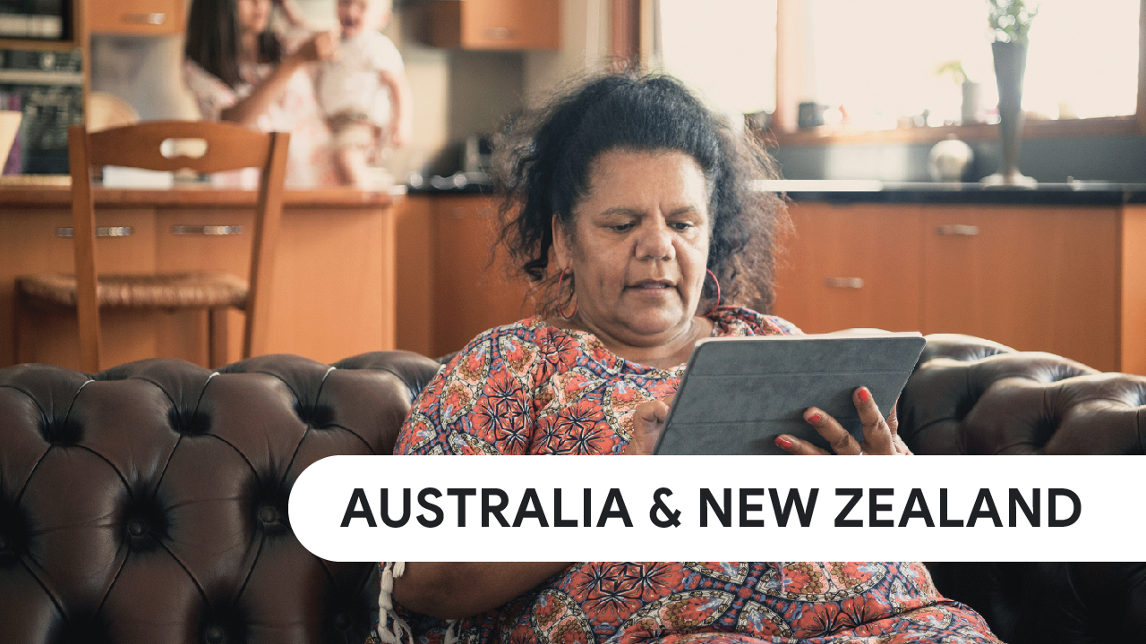 Australia & New Zealand. A woman sitting on a sofa uses a tablet for Search.