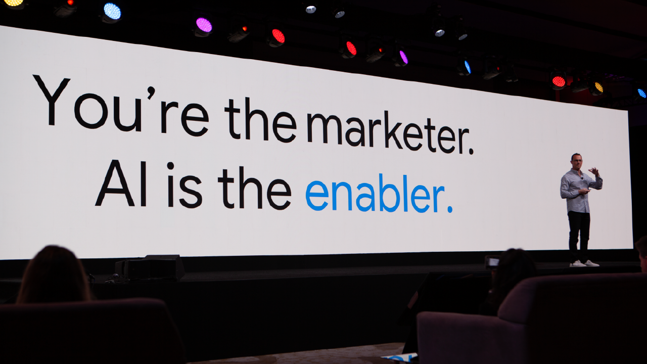 Google'ın küresel ticaretten sorumlu başkan yardımcısı Jason Spero, 2024 Annual Leadership Meeting'in (Yıllık Liderler Zirvesi) ana sahnesinde, "You're the marketer. AI is the enabler." (Sen pazarlamacısın, yapay zeka ise en büyük destekçin.) yazan büyük