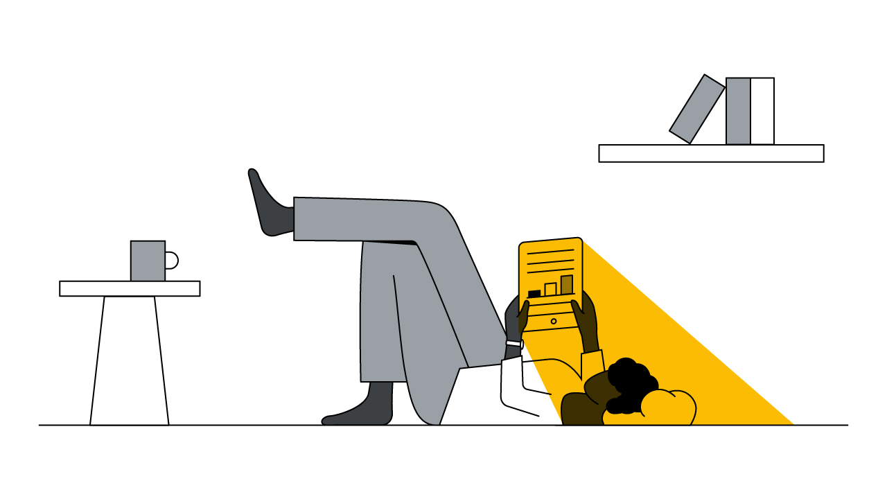 A man lies down on his back on the floor while reading an article on a tablet