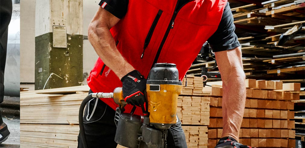 Uomo In Piedi In Officina A Indossare Guanti Da Lavoro