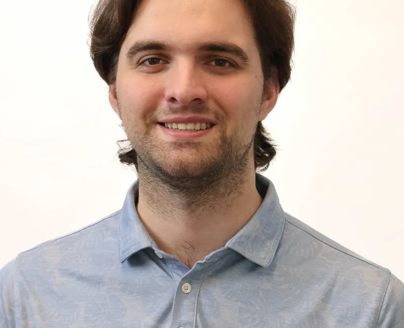 The photo is a profile photo of Christian 'CK' Kyle. He is wearing a light blue shirt and has brown hair.