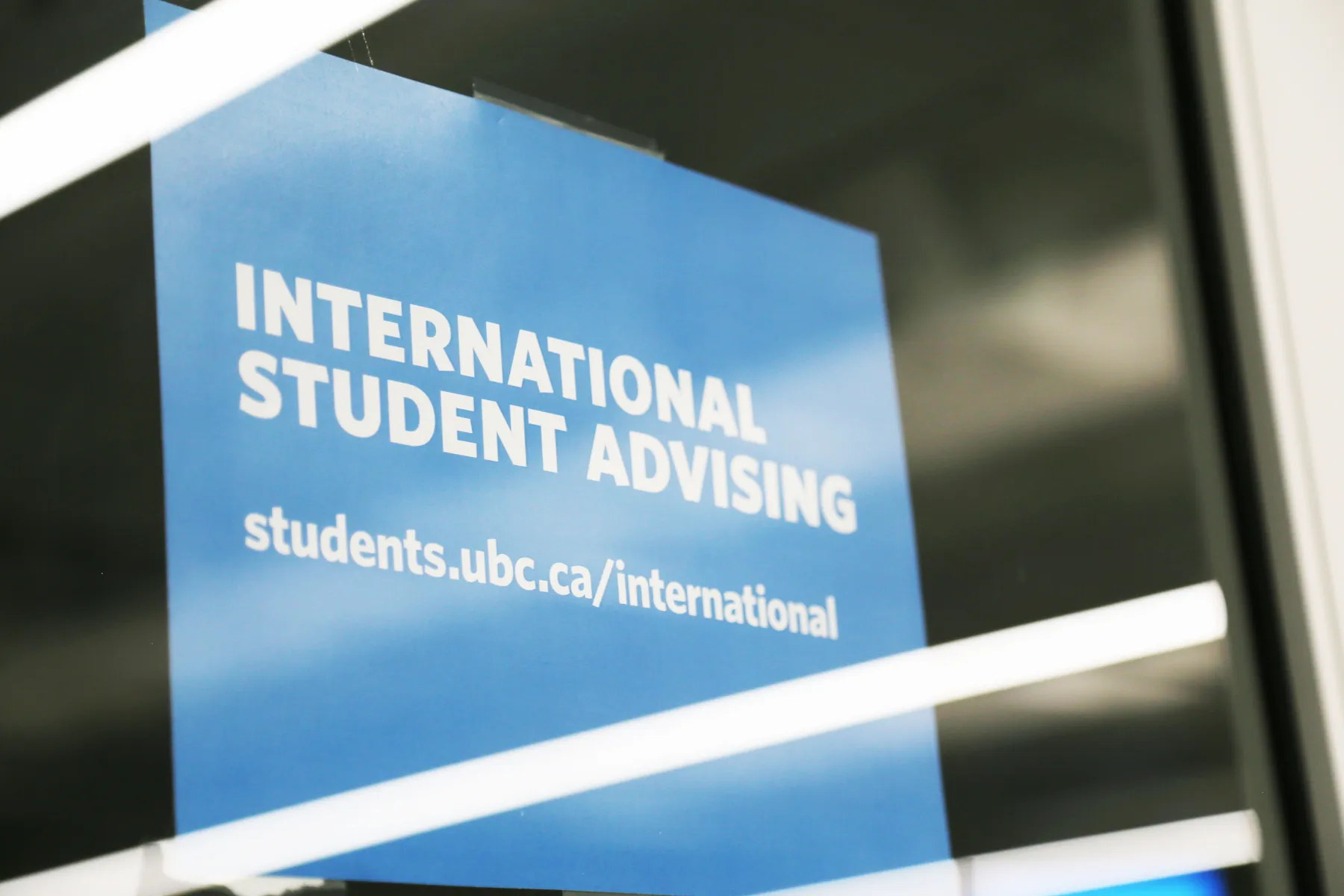 A sign advertising the international student advising office is displayed in a window.