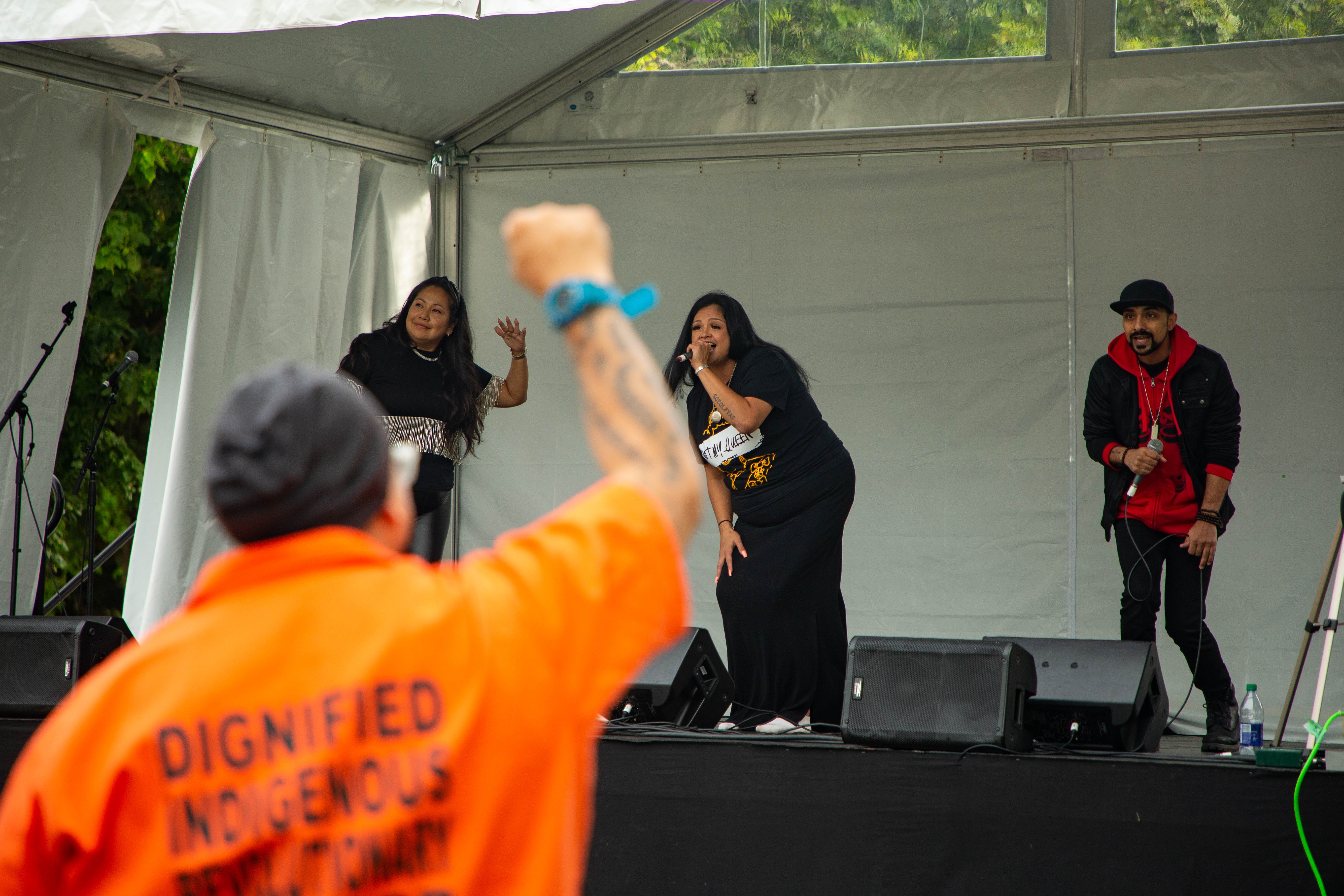 A festivalgoer makes a fist in solidarity as Miss Christie Lee, Lady Sinncere and DJ A-SLAM perform “Can’t Kill Me,” a rap dedicated to missing and murdered Indigenous women and girls.