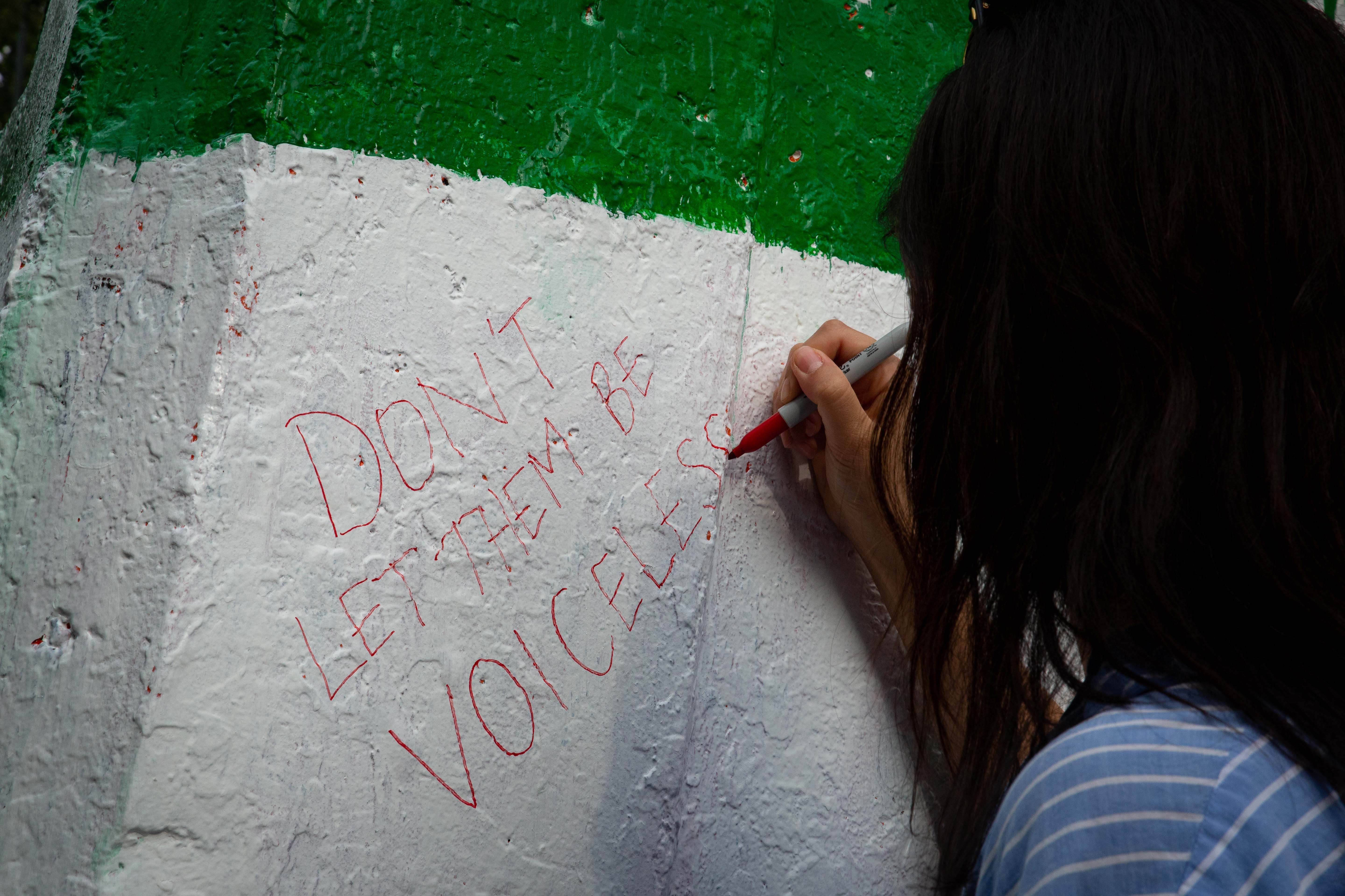 March attendees write messages of solidarity on the Engineering Cairn.