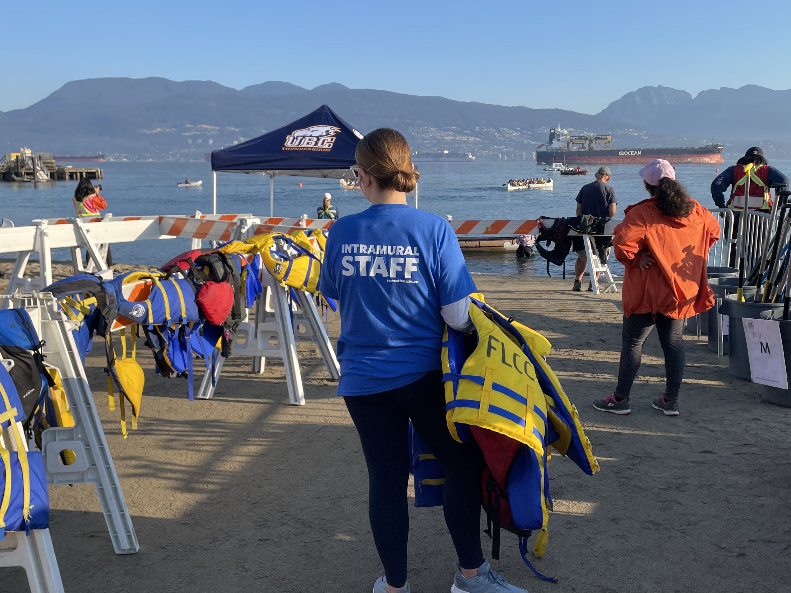 A student volunteer gets ready to hand out life jackets to the next heat of racers.