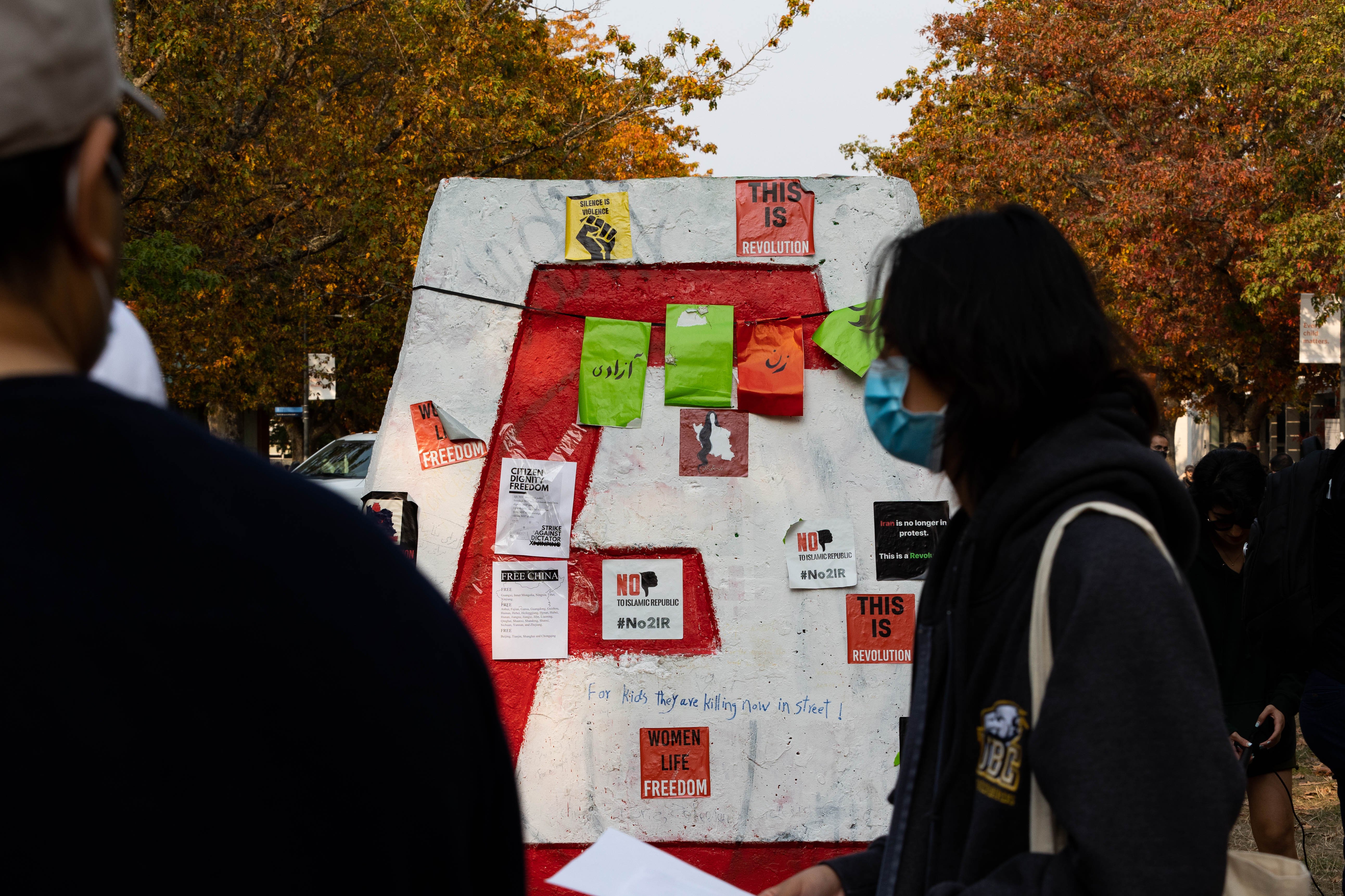 Messages and posters accumulate on the Engineering Cairn with each new protest.