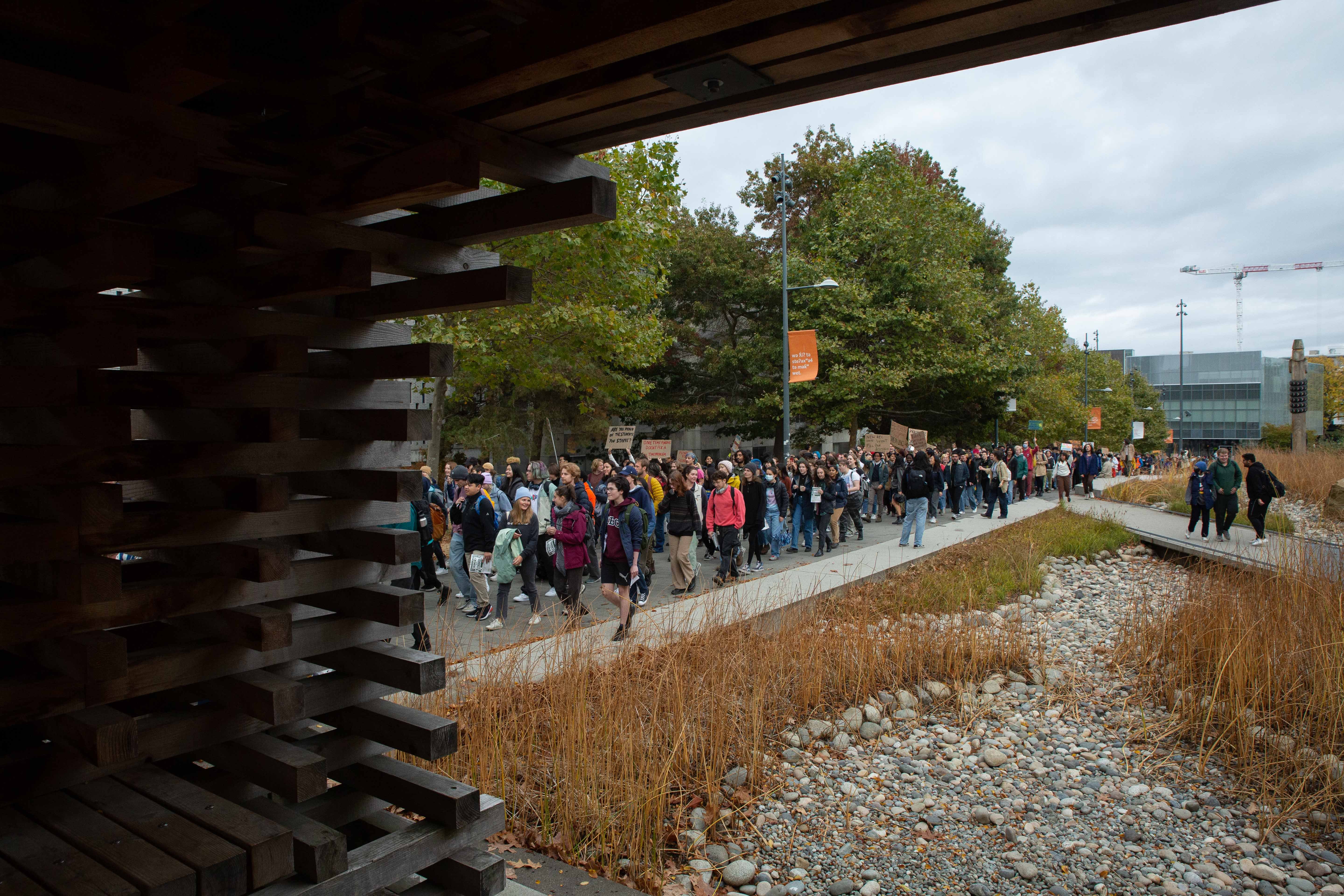 Hundreds of students march up University Boulevard toward Koerner Library.