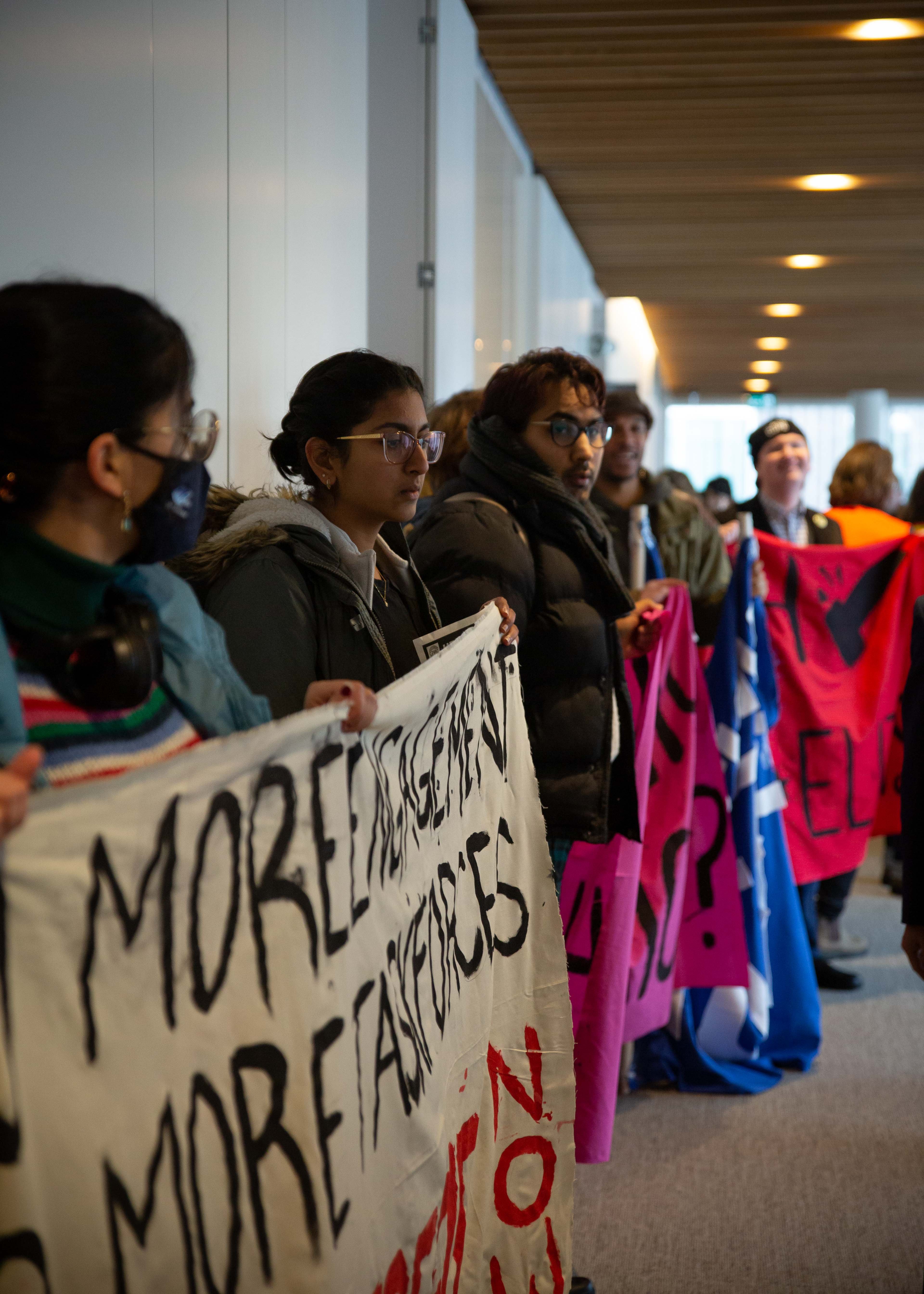 Protestors remained lined up outside the Robert H. Lee Family Boardroom through the Board of Governors meeting.