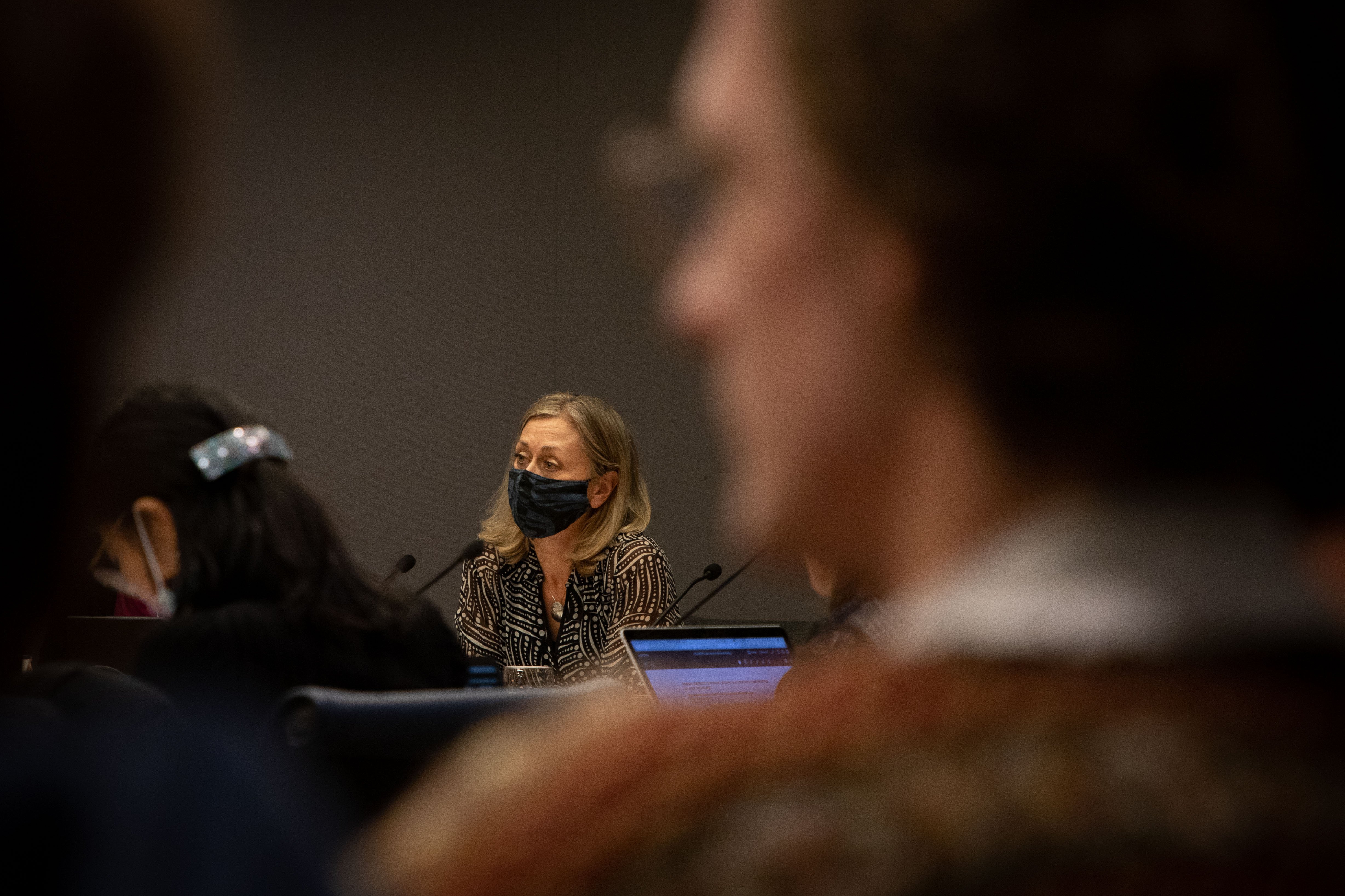 Board chair Nancy McKenzie sits during the meeting. Chris Munn, president of the UBC Pride Collective and one of the student speakers in attendance, sits in the foreground.