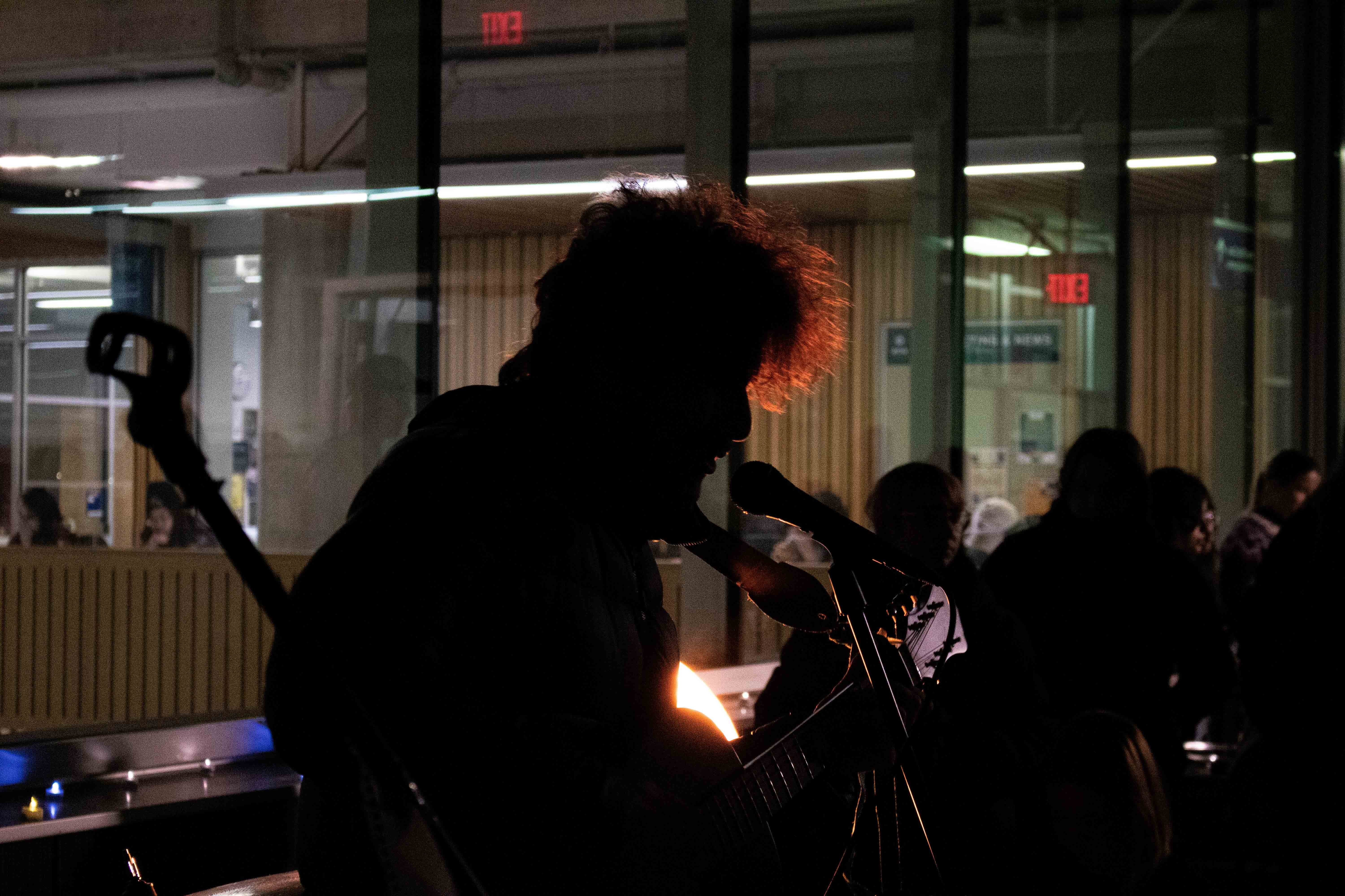 Michael Price, illuminated in orange, performs at Lights on the Roof.