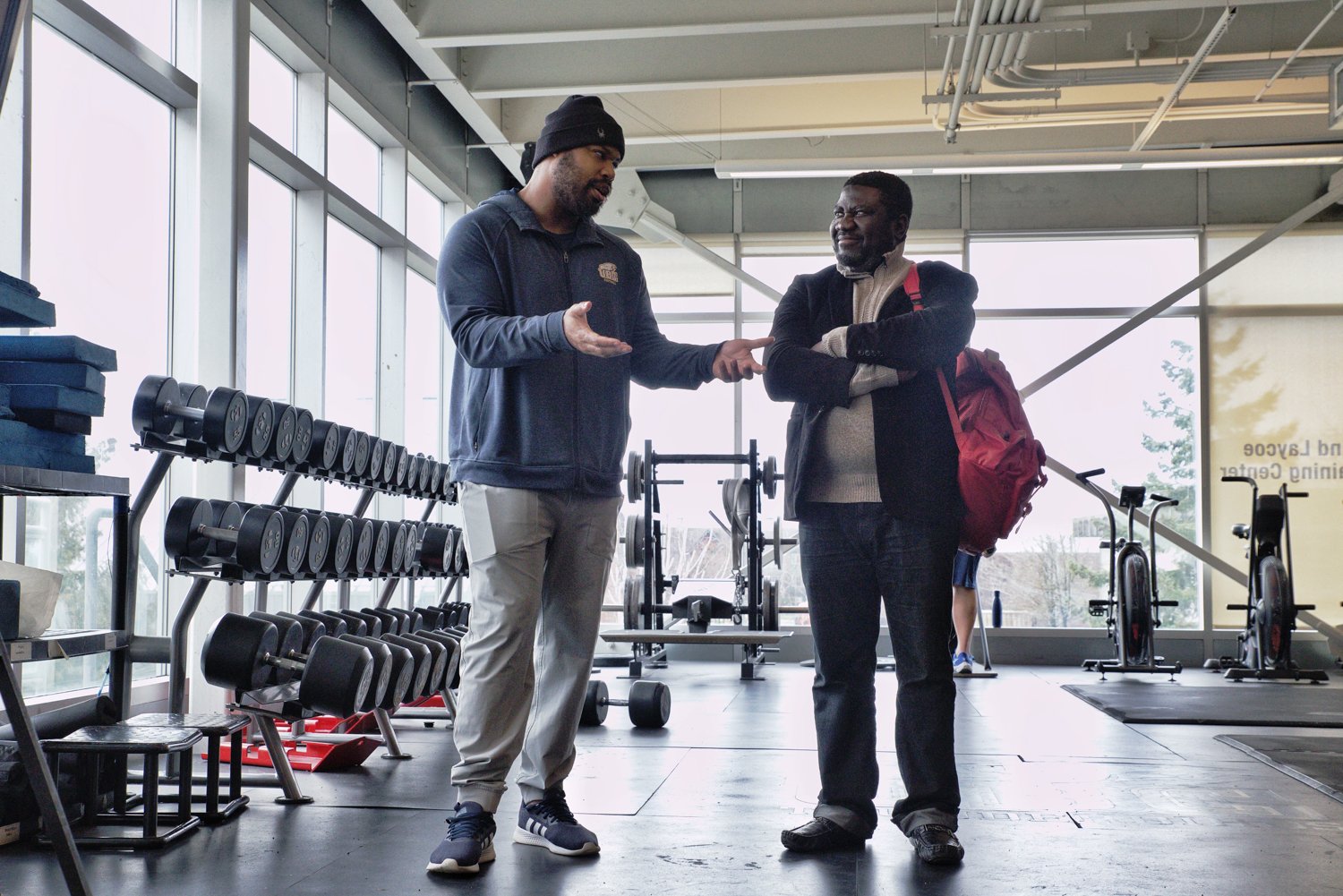 Williams talks with the parent of a potential football recruit in the Varsity Weight Room.