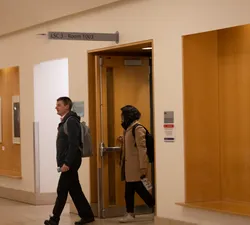 a photo of two people walking out of a door.