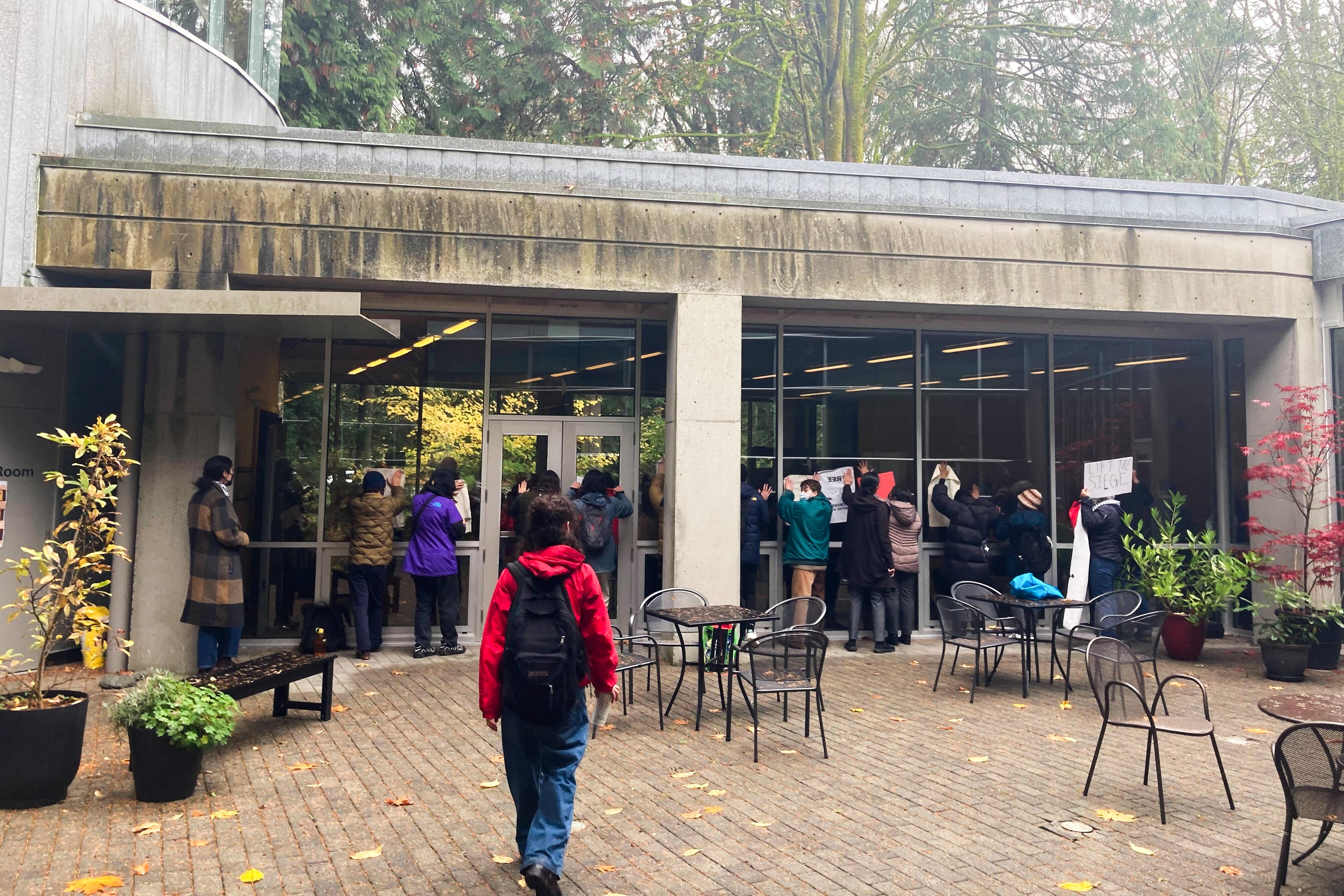 Protesters chanted with signs against the windows of the event venue.