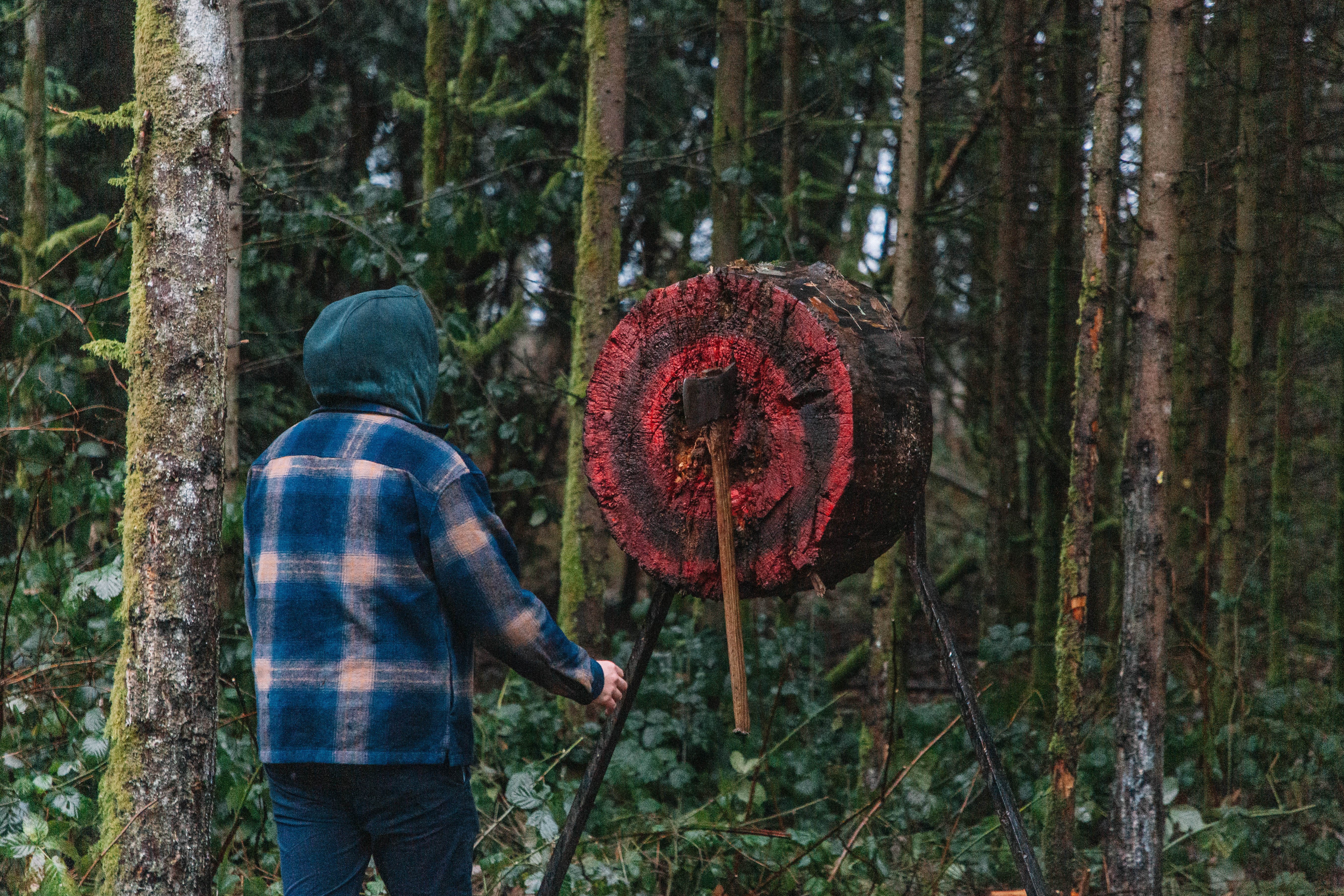 A student retrieves his thrown axe from the wooden target.