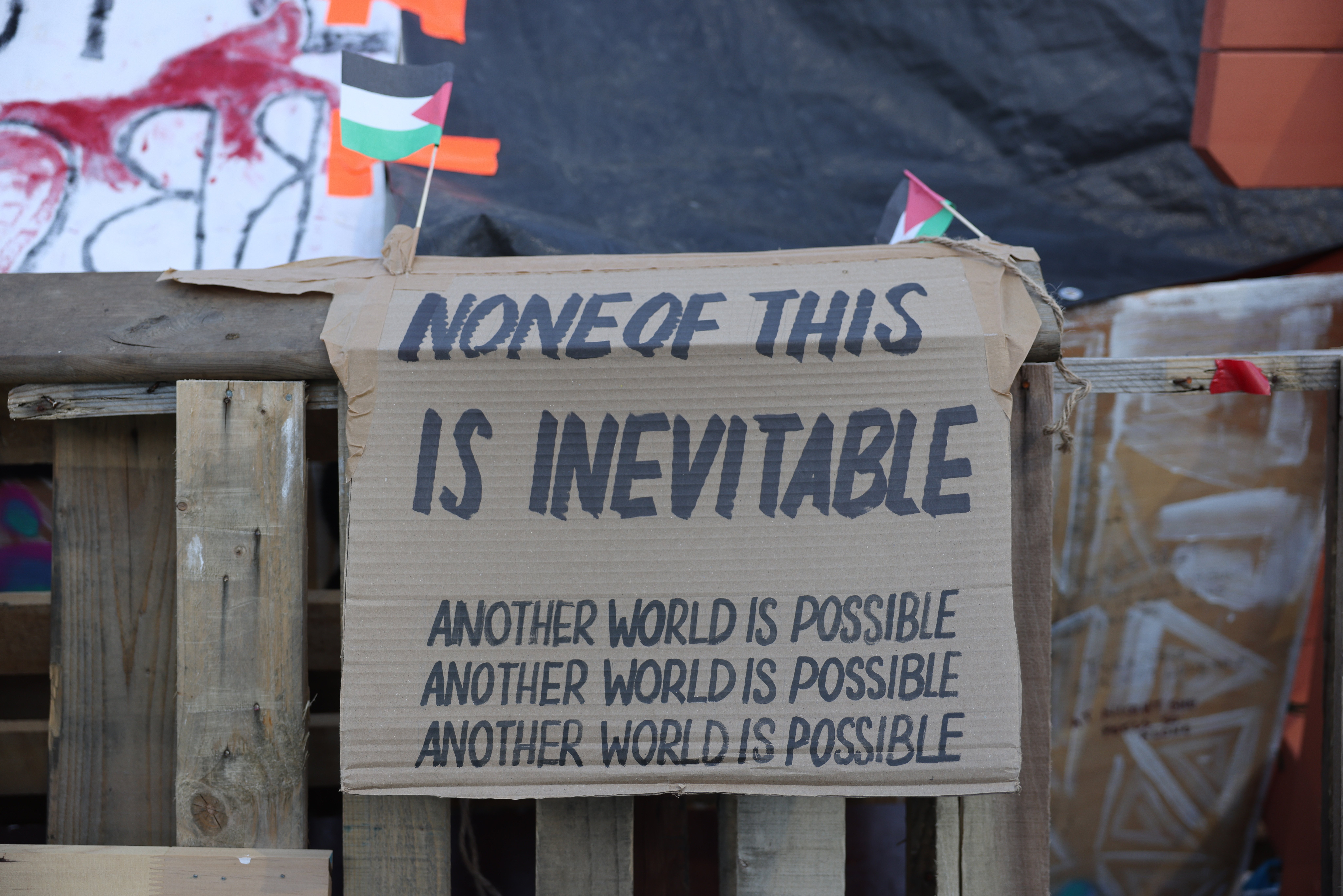 A sign which reads 'None of this is inevitable. Another world is possible.'
